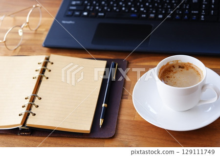 影像顯示,一名工作人員在辦公桌前工作,打開環形系統整理器,喝著咖啡(拿鐵咖啡),在電腦前進行案頭工作 影像顯示,一名工作人員在辦公桌前工作,打開環形系統整理器,喝著咖啡(拿鐵咖啡),在電腦前進行案頭工作 129111749