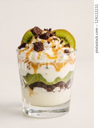 A gourmet layered dessert in a glass. This delicious parfait features layers of creamy yogurt, fresh kiwi fruit, and chocolate brownie, topped with a sweet caramel sauce. 129112231