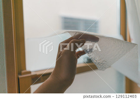 Peel the privacy sheet off the window glass 129112403