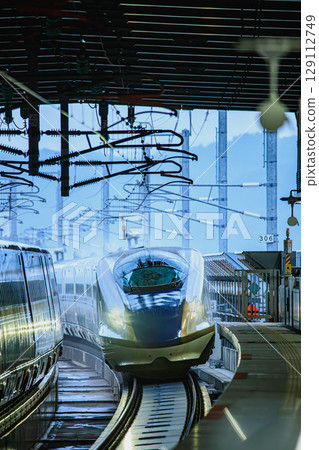 Rain-soaked platform and the arrival of the Shinkansen 129112749
