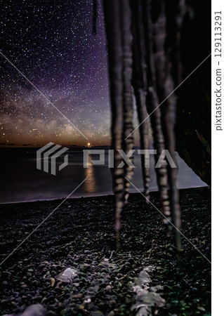 The Milky Way over the ocean at night, seen through icicles 129113291