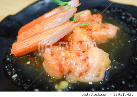 The Spicy Salmon Salad on the black plate 129113422