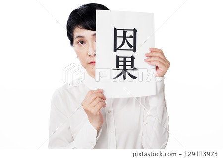A creepy middle-aged woman peers out from behind a piece of paper with the word "karma" written on it. 129113973