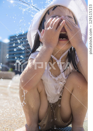 Children enjoying splashing around in a fountain in the summer sunshine Children enjoying splashing around in a fountain in the summer sunshine 129115153
