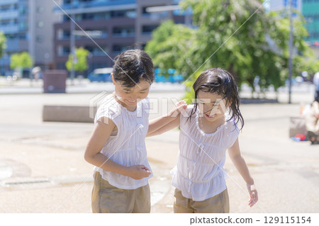 一個女孩在噴泉廣場上玩水 一個女孩在噴泉廣場上玩水 129115154