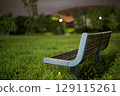 Park bench lit by street lamp 129115261