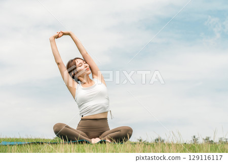 年輕的亞洲女性在藍天下做瑜珈、皮拉提斯和伸展運動 129116117