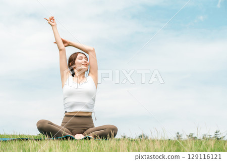 草原上做深呼吸、提神、瑜珈、伸展運動、皮拉提斯的女人（保健/飲食） 129116121