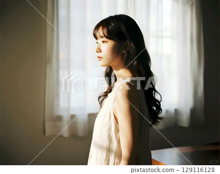 Calm Woman with Long Hair Standing by Window in Soft Natural Light Creating Peaceful and Reflective Mood Indoors 129116128
