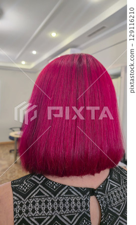 Bright red hair. Hair dyeing and drying process in a beauty salon. Medium length Bright red hair. Hair dyeing and drying process in a beauty salon. Medium length 129116210