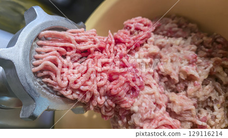 Meat grinder with fresh minced meat on the kitchen table Close-up of minced meat Meat grinder with fresh minced meat on the kitchen table Close-up of minced meat 129116214