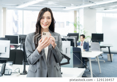 在辦公室工作的年輕女商人 129116457