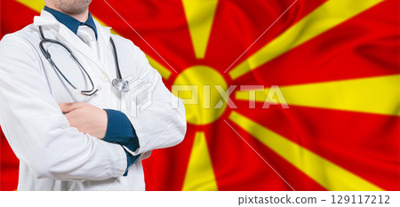 North Macedonia healthcare concept. Male doctor on North Macedonia flag. Doctor with crossed arms on North Macedonia flag 129117212