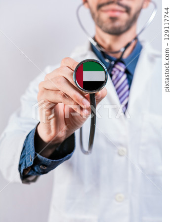 United Arab Emirates health and medical insurance concept. United Arab Emirates healthcare system, doctor holding stethoscope United Arab Emirates health and medical insurance concept. United Arab Emirates healthcare system, doctor holding stethoscope 129117744
