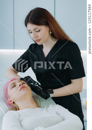young woman getting an injection procedure in aesthetic clinic. Beauty treatment young woman getting an injection procedure in aesthetic clinic. Beauty treatment 129117984