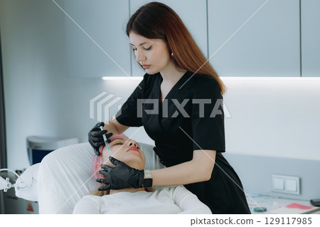young woman getting an injection procedure in aesthetic clinic. Beauty treatment 129117985