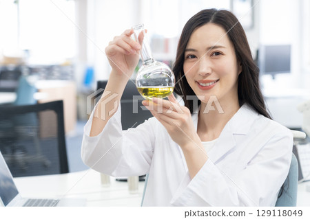 一位身穿白大褂的年輕女研究員在實驗室進行實驗 129118049
