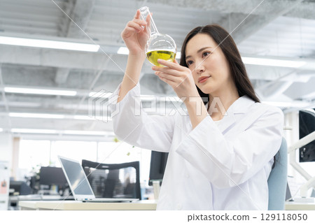 一位身穿白大褂的年輕女研究員在實驗室進行實驗 129118050