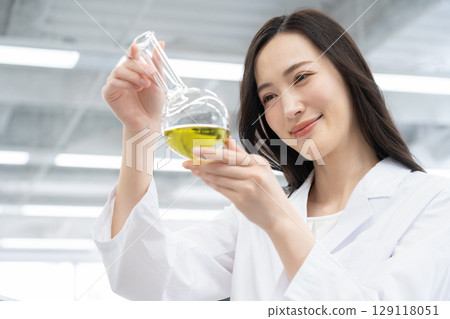 一位身穿白大褂的年輕女研究員在實驗室進行實驗 129118051