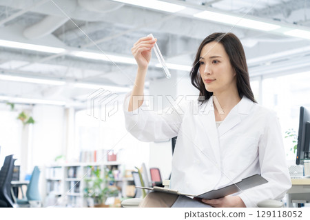 一位身穿白大褂的年輕女研究員在實驗室進行實驗 129118052