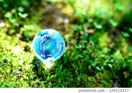 A beautiful globe crystal in the backlit grass. Ecological image. Soft blue color. 129118377