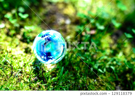 A beautiful globe crystal in the backlit grass. Ecological image. Blue. 129118379