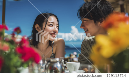 Summer beach resort: Men and women enjoying themselves on the cafe terrace 129118714