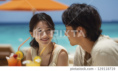 夏日海灘勝地：男男女女在遮陽傘下玩樂 129118719