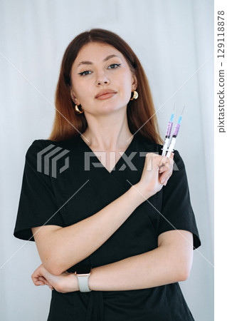 skilled aesthetician woman professional wearing black medical suit holding syringes skilled aesthetician woman professional wearing black medical suit holding syringes 129118878