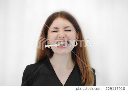 skilled aesthetician woman professional wearing black medical suit holding syringes 129118918