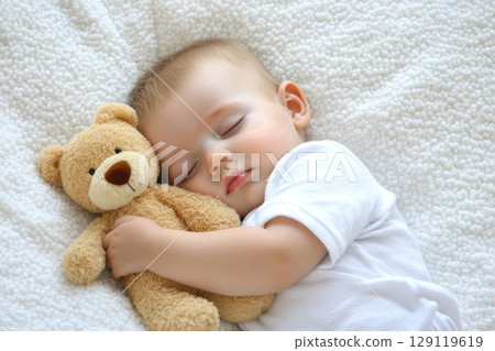 Image of a sleeping baby with a teddy bear. The atmosphere of coziness, safety and calm. The concept of advertising baby products, motherhood, articles about education. Care and well-being of babies 129119619