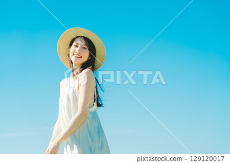 藍天背景下穿夏裝的女人 129120017