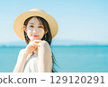 戴著草帽的女人，背景是海和藍天 129120291