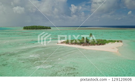 Aerial view serene tropical island with white sand beach and vibrant palm trees. Crystal-clear turquoise water extend into the horizon. Remote wild nature paradise, exotic summer travel background 129120606