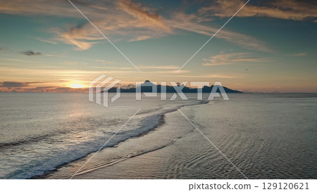 Bora Bora island rising majestically from the pacific ocean at sunset, showcasing a stunning and tranquil landscape filled with calm waves and a vibrant, colorful sky Bora Bora island rising majestically from the pacific ocean at sunset, showcasing a stunning and tranquil landscape filled with calm waves and a vibrant, colorful sky 129120621