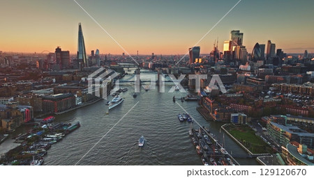Aerial view of London skyline,The Shard, Tower Bridge, River Thames at colorful sunset, urban city landscape, boats sailing, iconic landmarks. United Kingdom travel destination. Drone flight Aerial view of London skyline,The Shard, Tower Bridge, River Thames at colorful sunset, urban city landscape, boats sailing, iconic landmarks. United Kingdom travel destination. Drone flight 129120670