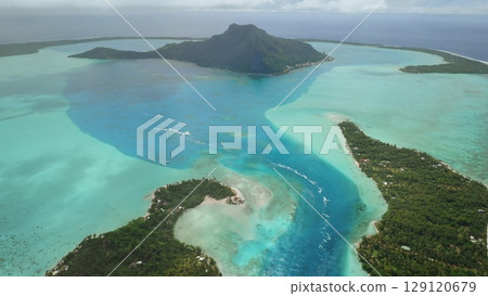 Aerial view capturing Bora Bora lush vegetation, crystal clear turquoise water, intricate lagoon channels, creating breathtaking tropical paradise in French Polynesia. Remote wild nature destination Aerial view capturing Bora Bora lush vegetation, crystal clear turquoise water, intricate lagoon channels, creating breathtaking tropical paradise in French Polynesia. Remote wild nature destination 129120679