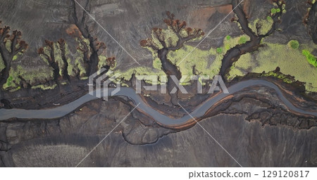 Fiji, Tana Island: Aerial drone revealing a sinuous river winding through the striking volcanic landscape of Port Resolution. Wild nature travel landscape. Top down flight 129120817