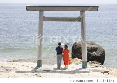 一對夫婦站在海岸邊的鳥居門前 129121124