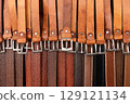 Selection of brown leather belts offered at a market stall 129121134