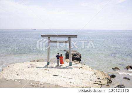 一對夫婦站在海岸邊的鳥居門前 129121170