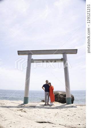 一對夫婦站在海岸邊的鳥居門前 129121231