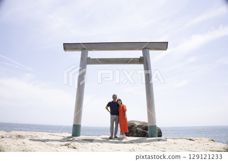 一對夫婦站在海岸邊的鳥居門前 129121233