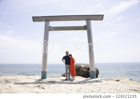 一對夫婦站在海岸邊的鳥居門前 129121235
