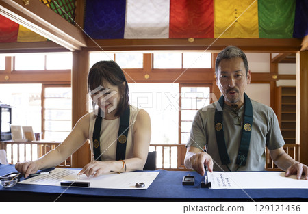 A couple experiencing copying sutras at a temple A couple experiencing copying sutras at a temple 129121456