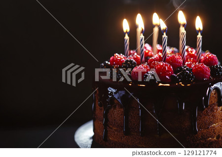 Birthday cake decorated with chocolated frosting, berries and  birthday candles. Birthday cake decorated with chocolated frosting, berries and  birthday candles. 129121774