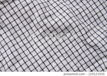 Plaid material. Towel on the table. Wrinkled fabric with stripes. Plaid material. Towel on the table. Wrinkled fabric with stripes. 129121930
