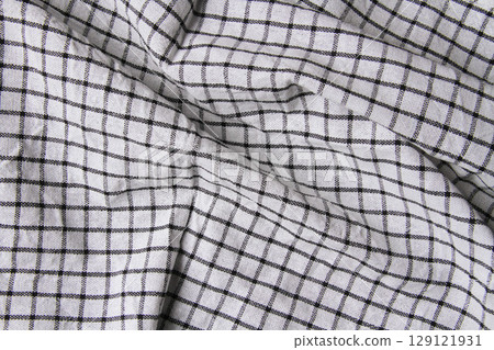 Plaid material. Towel on the table. Wrinkled fabric with stripes. Plaid material. Towel on the table. Wrinkled fabric with stripes. 129121931