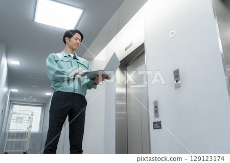 Young male engineer doing office maintenance Young male engineer doing office maintenance 129123174