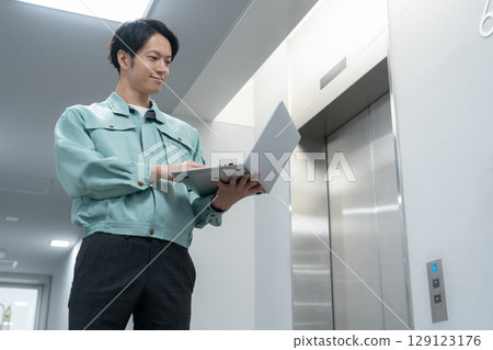 Young male engineer doing office maintenance Young male engineer doing office maintenance 129123176